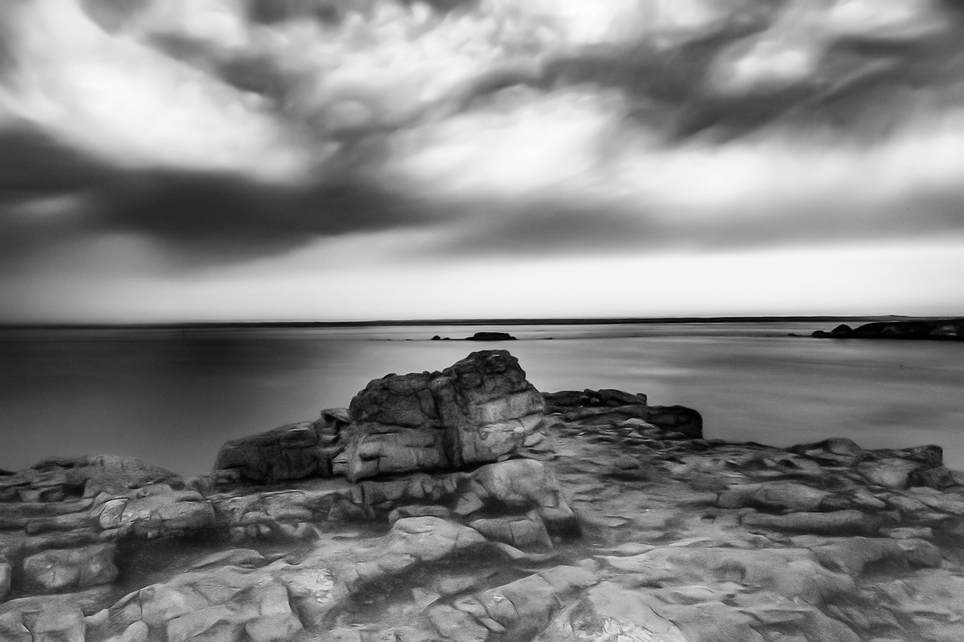 Rocher au premier plan sous un ciel d’orage coloré au cap de Pen Hir en Bretagne, noir et blanc