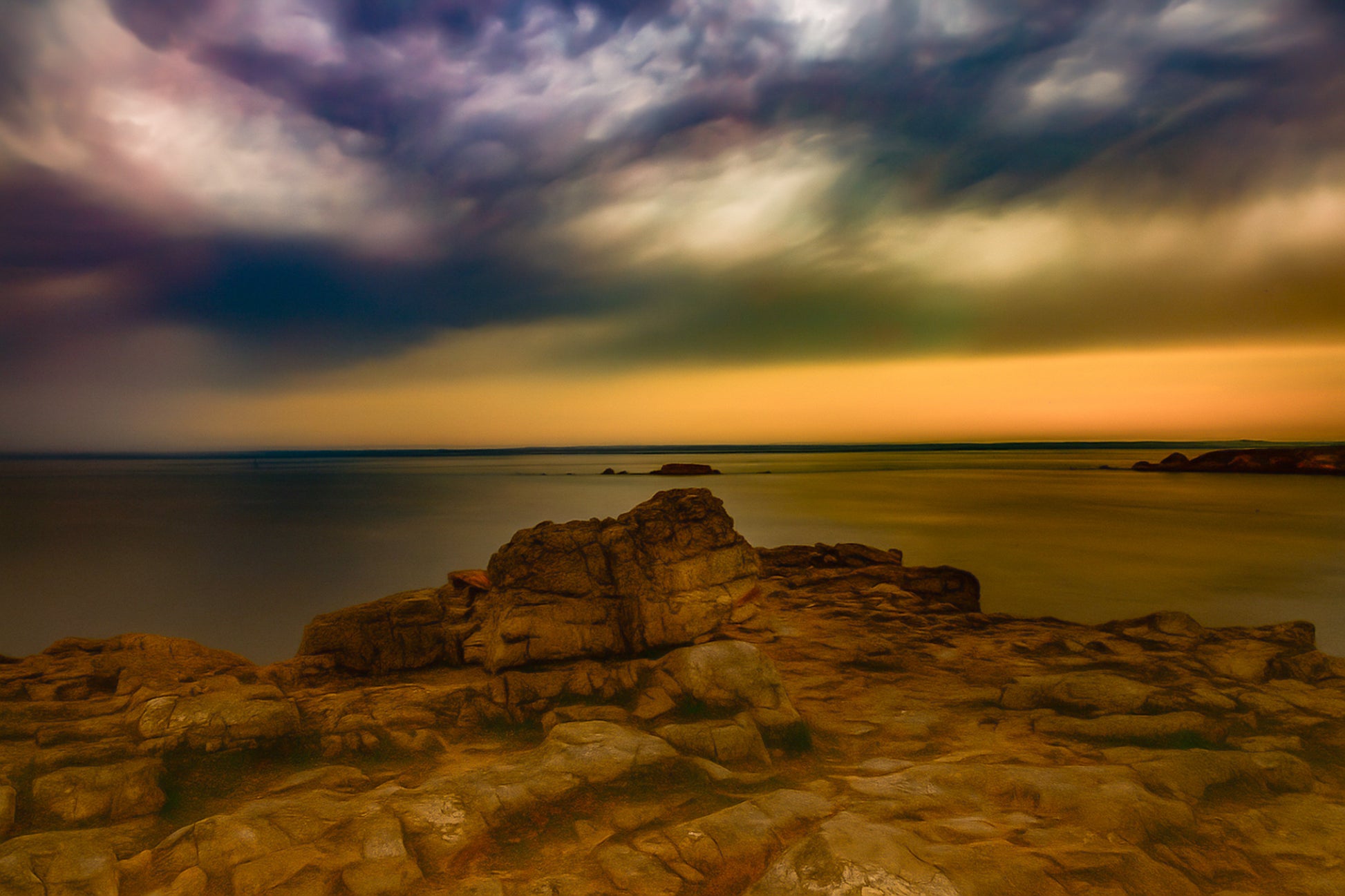 Rocher au premier plan sous un ciel d’orage coloré au cap de Pen Hir en Bretagne