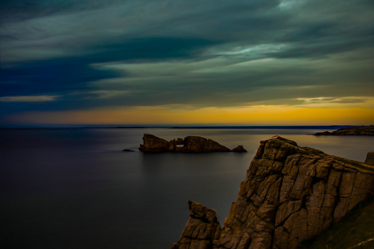 Îlot rocheux percé d’une arche au large de Pen Hir, ciel orageux et mer calme