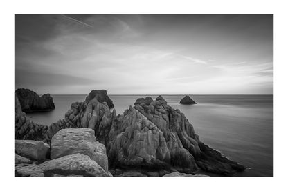 Rochers des Tas de Pois à Pen Hir au crépuscule, mer calme et ciel bleu orangé, noir et blanc et bordure