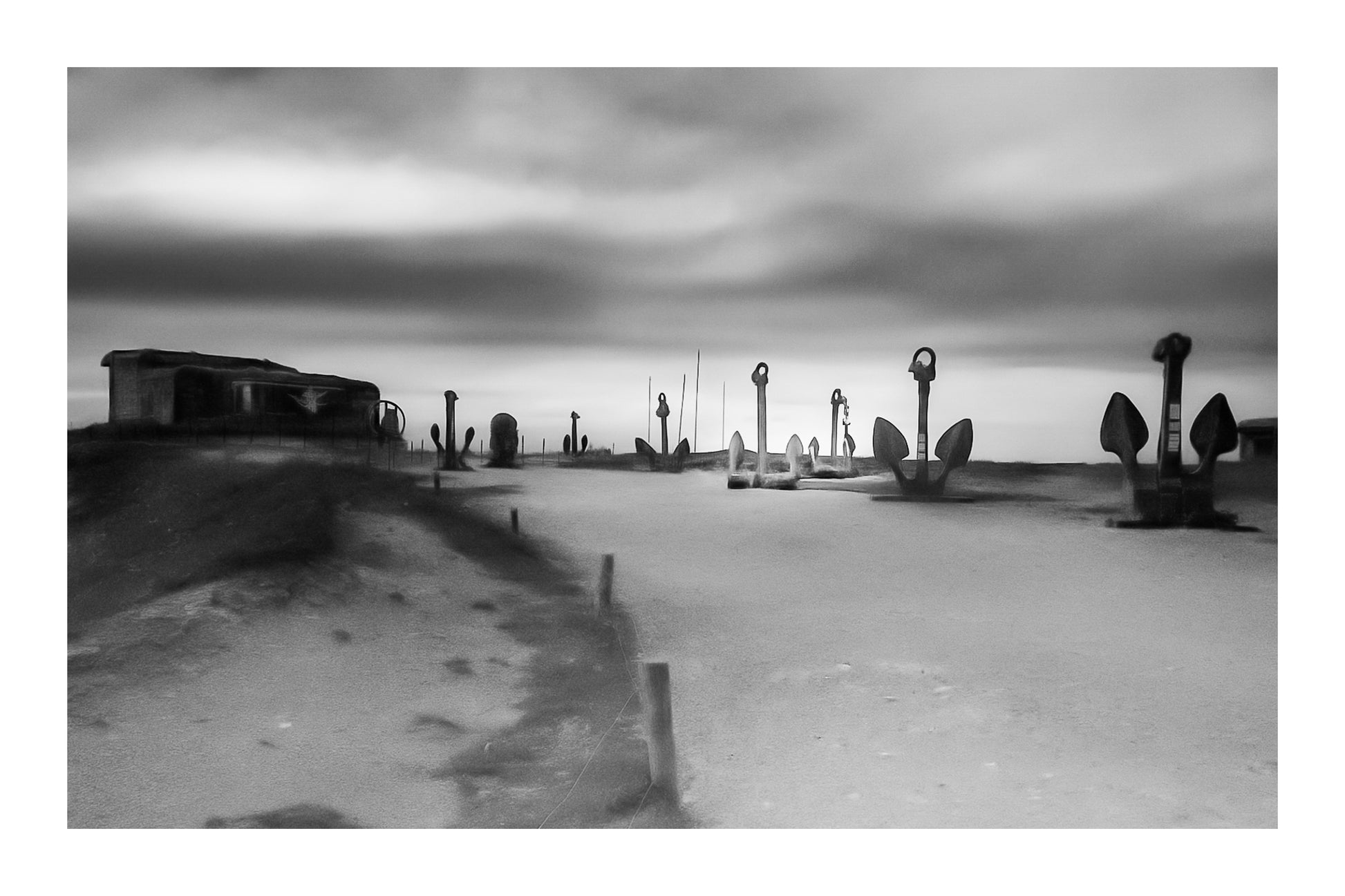 Alignement d’ancres marines sur le plateau de Pen Hir au coucher du soleil, noir et blanc avec bordure