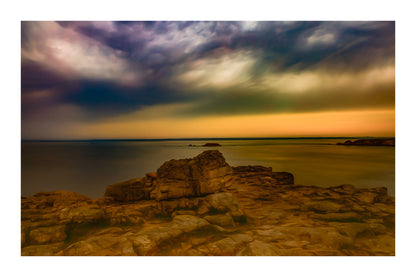 Rocher au premier plan sous un ciel d’orage coloré au cap de Pen Hir en Bretagne avec bordure