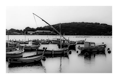 Barques traditionnelles serrées au port du Brusc au coucher du soleil, reflets dorés, noir et blanc avec bordure