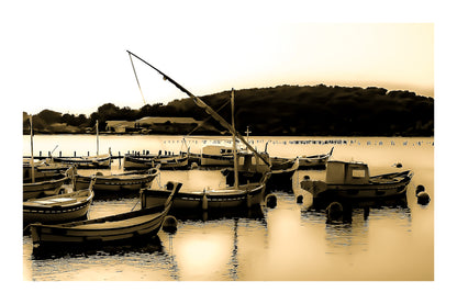 Barques traditionnelles serrées au port du Brusc au coucher du soleil, reflets dorés, traitement vintage sépia avec bordure