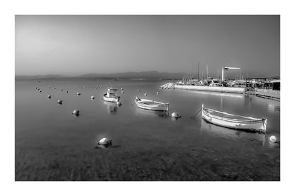 Barques au mouillage face au quai et aux mats du port du Brusc, fin de journée, noir et blanc avec bordure