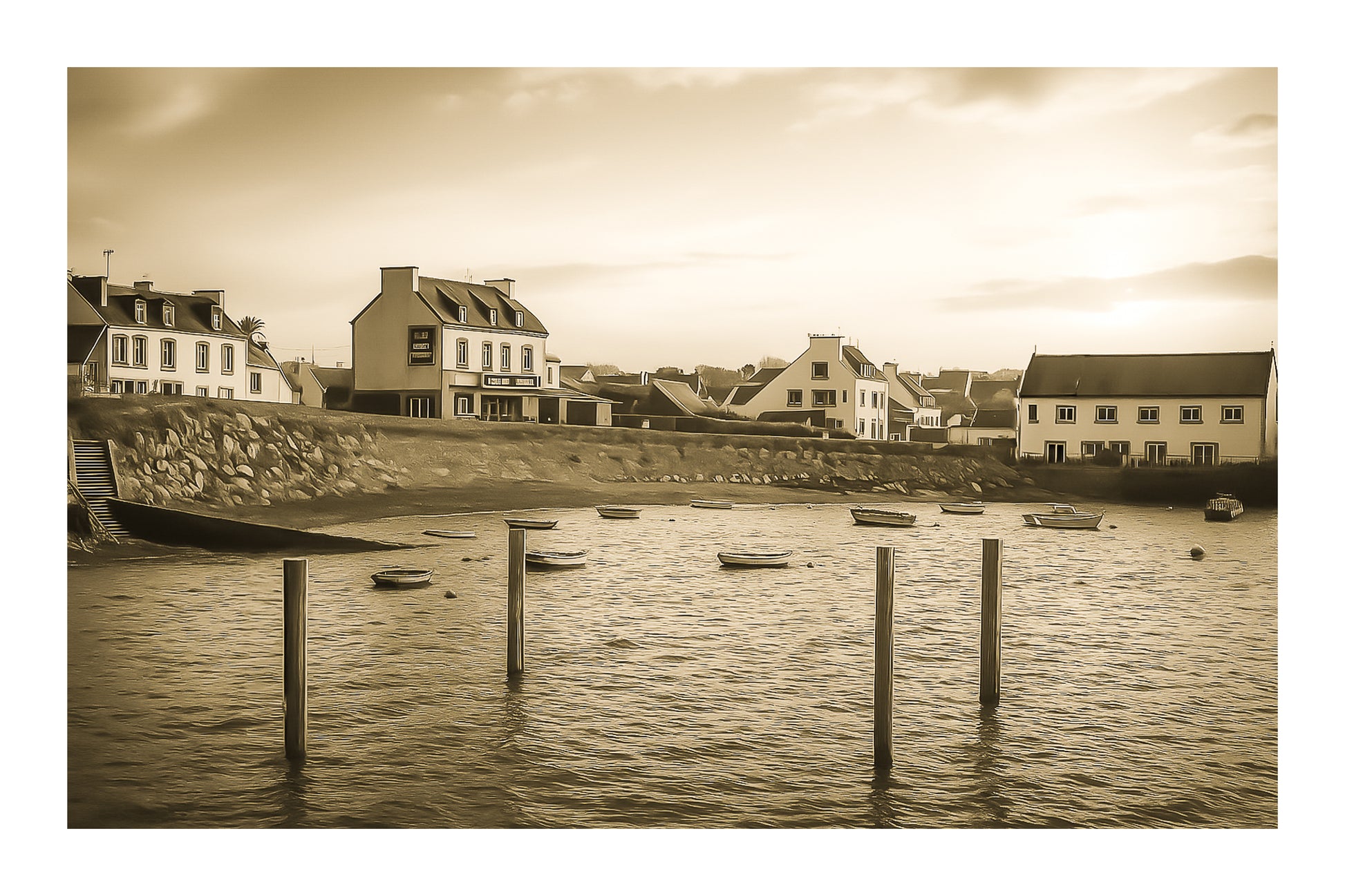 Maisons du bord de mer à Portsall baignées de lumière dorée, poteaux d’amarrage et barques dispersées sur l’anse, vintage avec bordure