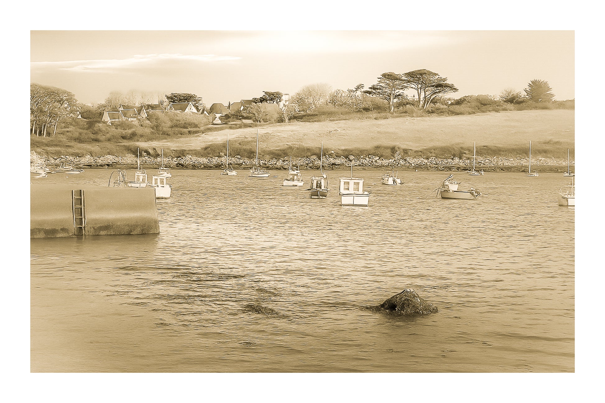 Panorama de la ria de Portsall avec nombreux bateaux au mouillage, coteau arboré en arrière-plan, lumière de fin de journée, vintage avec bordure