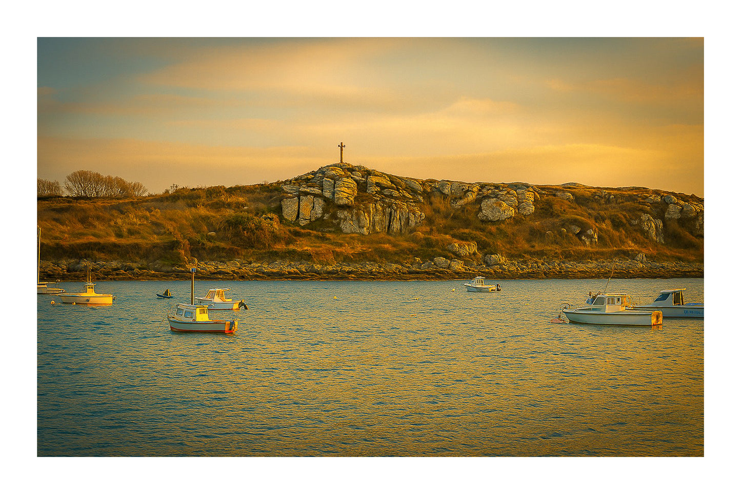 Croix dressée sur un îlot rocheux à l’entrée du port de Portsall, mer calme et bateaux épars sous un ciel doré avec bordure