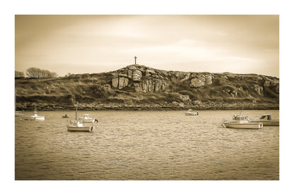 Croix dressée sur un îlot rocheux à l’entrée du port de Portsall, mer calme et bateaux épars sous un ciel doré, vintage avec bordure