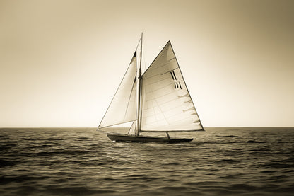 Voilier classique en navigation au coucher du soleil sur une mer calme en Méditerranée, voiles dorées par la lumière, vintage