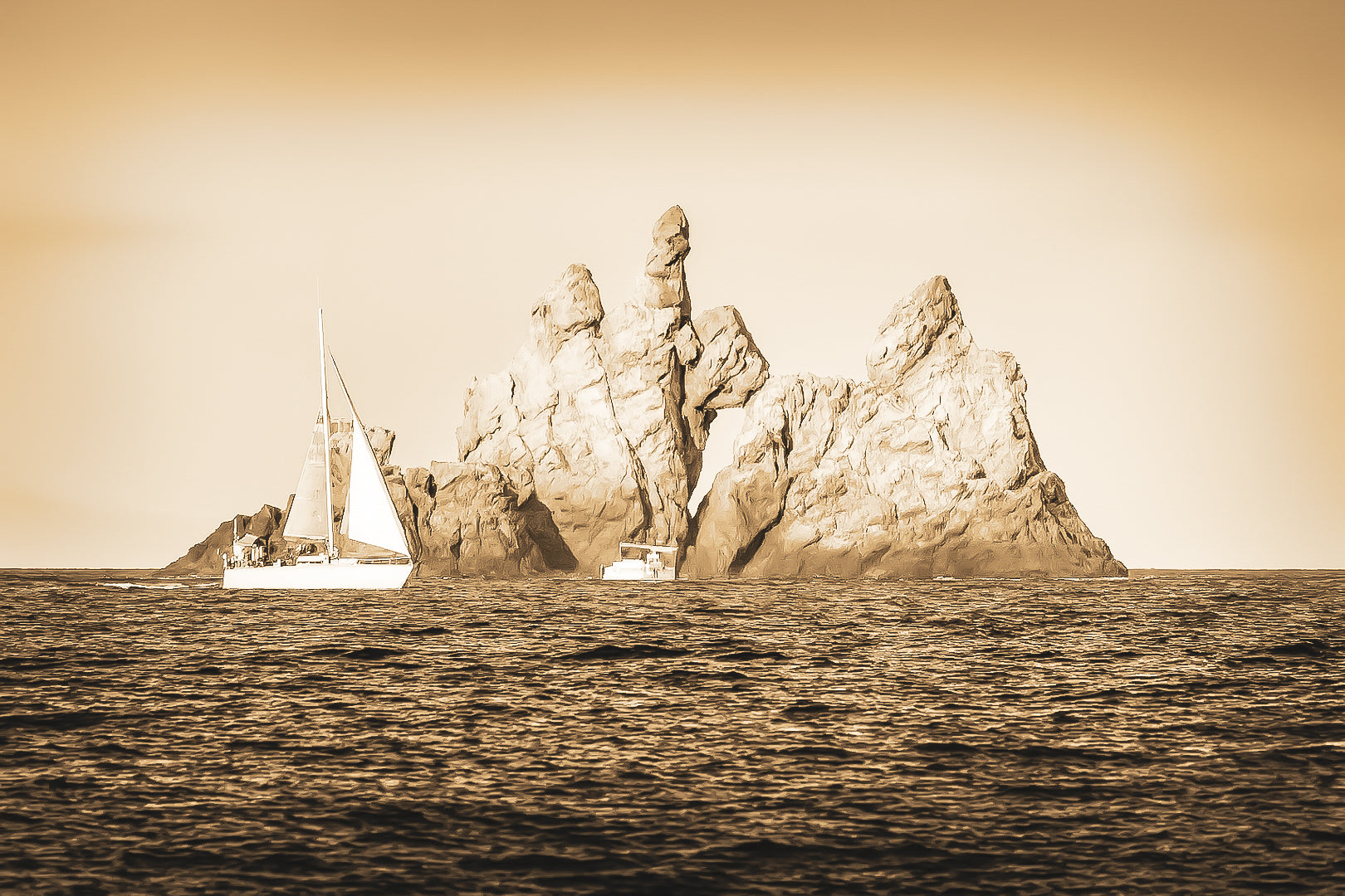 Voilier longeant un massif rocheux percé d’une arche en Méditerranée, lumière rasante de fin de journée, vintage